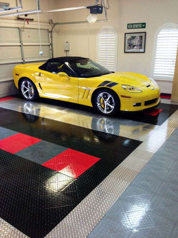 A yellow Corvette in a garage with RaceDeck Pro accents